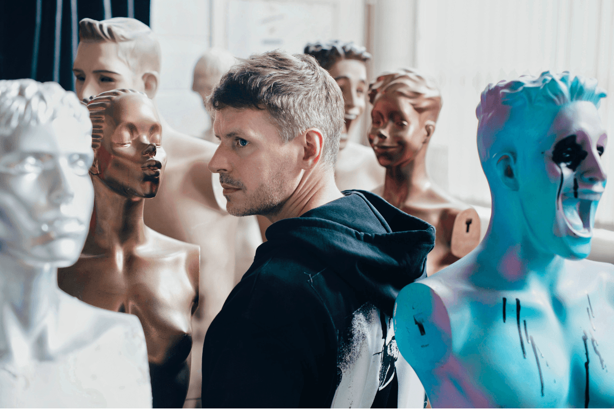 man standing in the middle of some mannequins&nbsp;