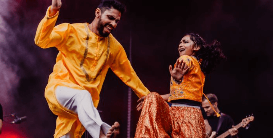 two people in orange outfits dancing on stage