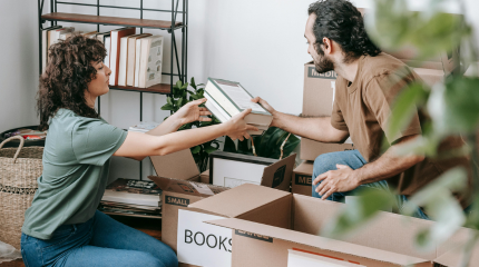 A young man and woman sorting through boxes of books