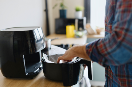 Close up of a man arranging baking parchment in his air fryer