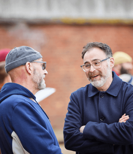 Two individuals chatting in an outdoor community setting