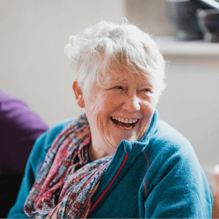 Older customer sitting relaxed and laughing as they chat to an SNG employee