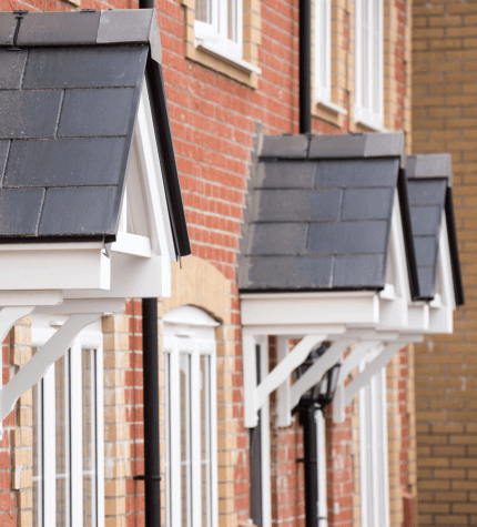 Image shows a row of houses in Dorset with front porch canopies