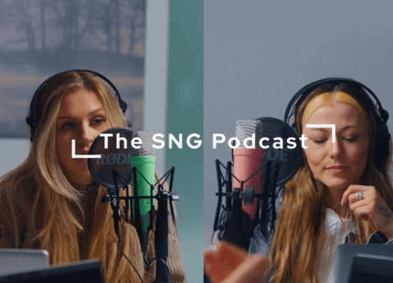 Podcast host Phoebe Newton is sat talking into a microphone as guest speaker looks down 