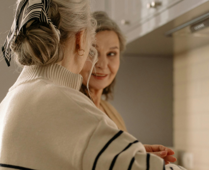 Two middle-aged ladies having a chat whilst making a cup of tea