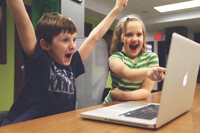Two children looking at a laptop