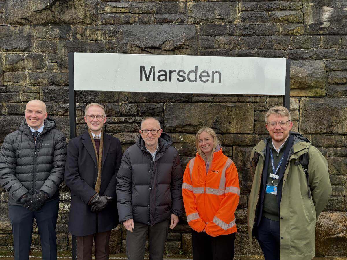 Paul Davies MP with a group of people in front of Marsden train station sign