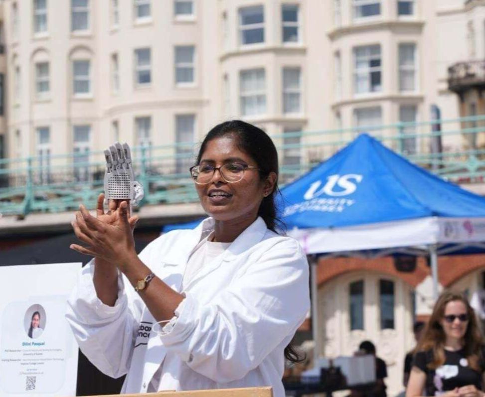 Dilini Pasqual demonstrates a robotic hand to visitors at a Soapbox Science event.