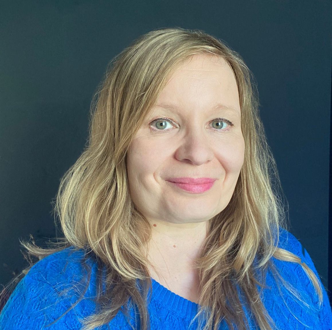 Professor Mari Martiskainen smiling, wearing a cobalt blue top.