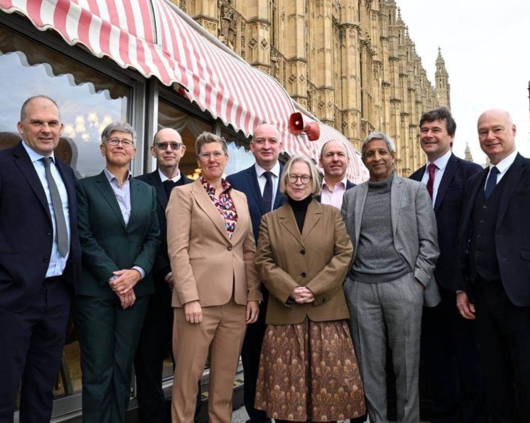 Ten vice-chancellors from the founding ResearchPlus universities standing outside the Houses of Parliament in formal attire.